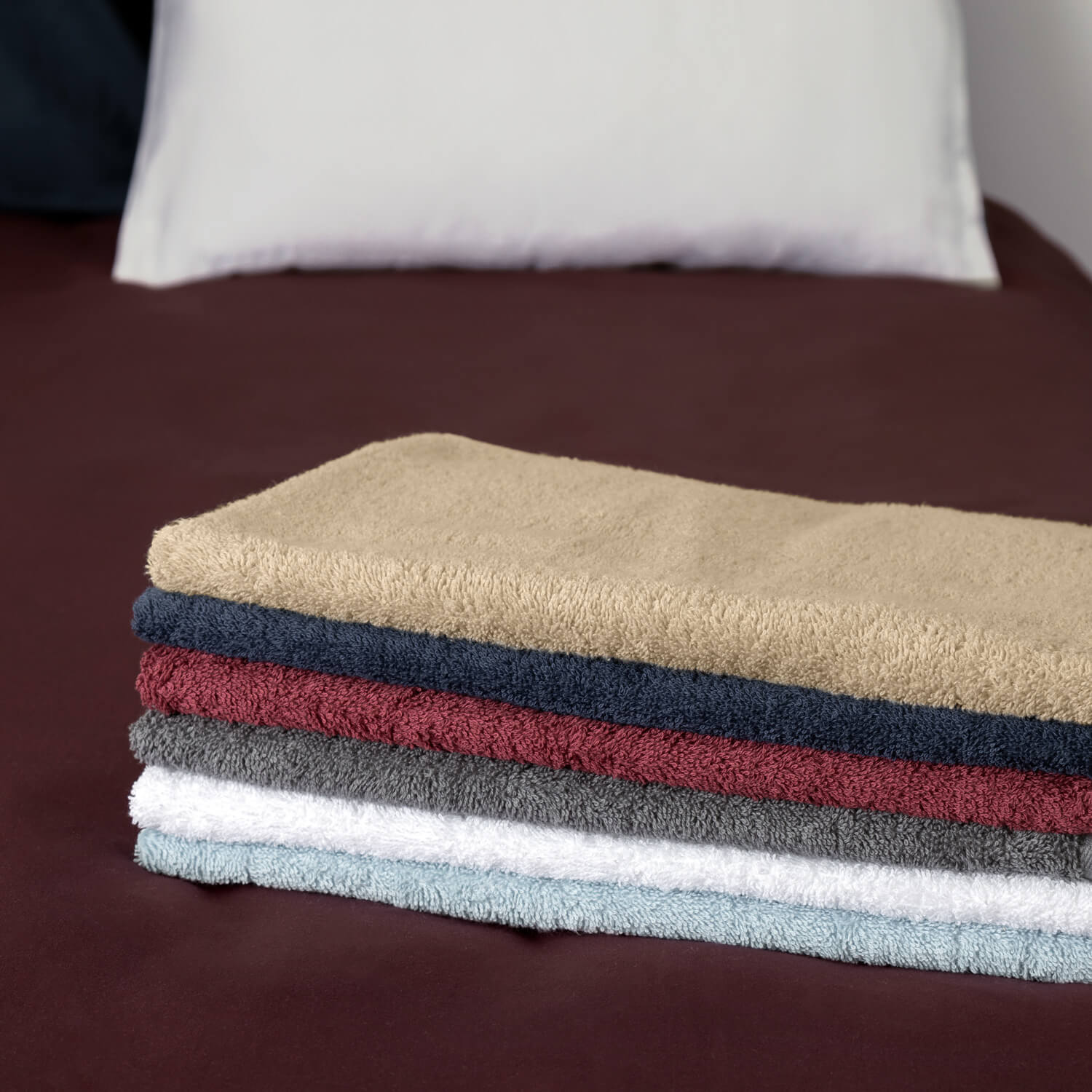 Pino puhtaita työtekstiilipyyhkeitä viikattuna, eri väreissä